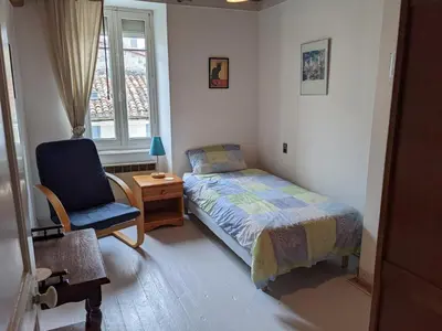a bedroom with a bed and a chair and a window at Pyrenees,Hiking, Cycling, Rafting,Fishing,4 Bed Apartment, Roof Terrace in Quillan