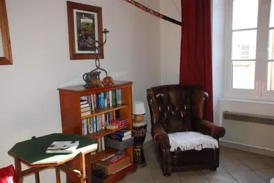 a living room with a chair and a book shelf with books at Pyrenees,Hiking, Cycling, Rafting,Fishing,4 Bed Apartment, Roof Terrace in Quillan