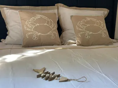 a bed with pillows with a crab on it at Appartement T2 Méditerranéen in Narbonne