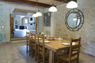 a dining room with a wooden table and chairs at Gite Les 3F in Fontcouverte