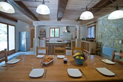 a wooden table with a bowl of fruit on it in a kitchen at Gite Les 3F in Fontcouverte