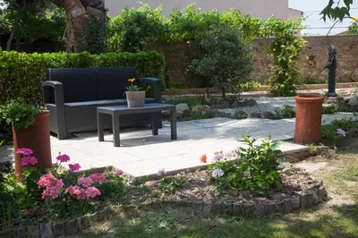 a garden with a bench and a table and flowers at Gite Les 3F in Fontcouverte