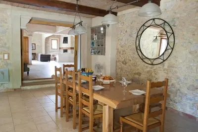 a dining room with a wooden table and chairs at Gite Les 3F in Fontcouverte