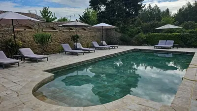 a swimming pool with chairs and umbrellas in a yard at Gite Les 3F in Fontcouverte