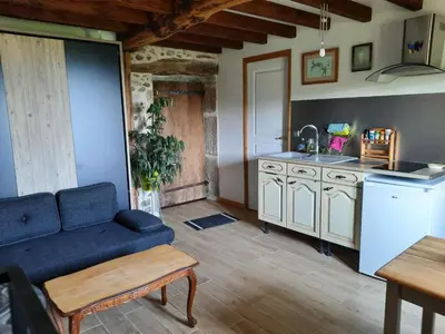 a living room with a blue couch and a kitchen at gîte les Libellules in Saint-Salvy-de-la-Balme