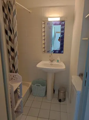 a bathroom with a sink and a mirror and a tub at 2 appartements mitoyens avec climatisation, piscine et parking - Plages et Port à 100m in Gruissan
