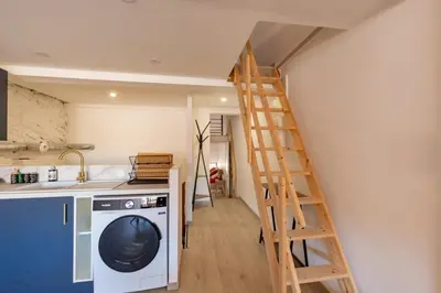 a kitchen with a ladder and a washing machine at La Cité Merveilleuse - Cité - Clim - Wifi in Carcassonne