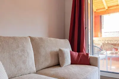 a living room with a couch with a red curtain at La Cité Merveilleuse - Cité - Clim - Wifi in Carcassonne