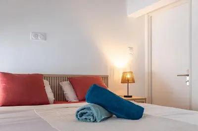 a blue pillow sitting on top of a bed at La Cité Merveilleuse - Cité - Clim - Wifi in Carcassonne