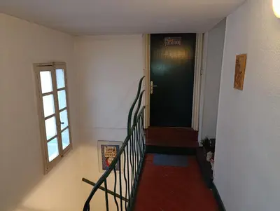 a hallway with a staircase leading to a door at Good Knight Inn in Carcassonne