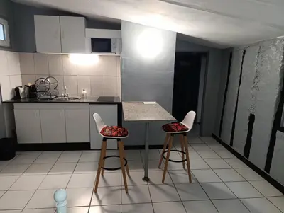 a kitchen with two stools and a table and a counter at Good Knight Inn in Carcassonne