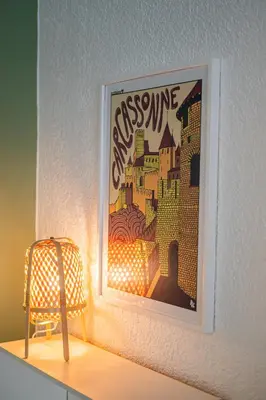 a painting on a wall with a chair and a lamp at 203 Balcon de la Bastide in Carcassonne