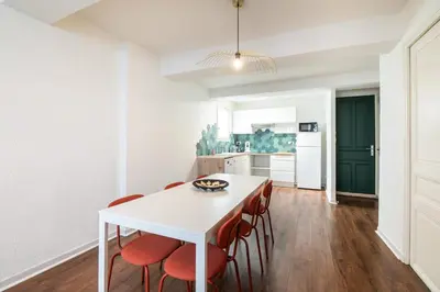a kitchen and dining room with a white table and chairs at 203 Balcon de la Bastide in Carcassonne
