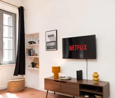 a living room with a television on a wall at T2 Design Centre Cité 10 min in Carcassonne