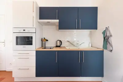a kitchen with blue and white cabinets and a sink at T2 Design Centre Cité 10 min in Carcassonne