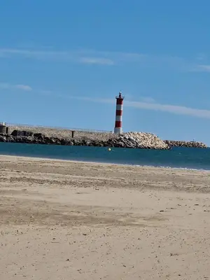a lighthouse sitting on the shore of a beach at Mobile Home climatisé 2 chambres Port La Nouvelle in Port-la-Nouvelle