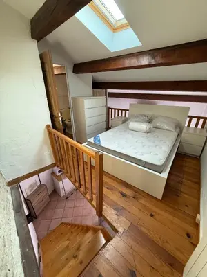 a bedroom with a large bed with a skylight at Petite maison in Castelnau-dʼAude