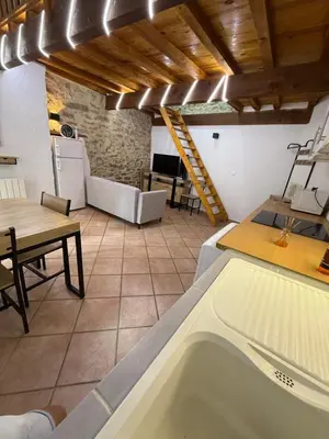a kitchen with a tub in a room with a table at Petite maison in Castelnau-dʼAude