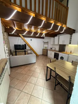 a large kitchen with a wooden table and a dining room at Petite maison in Castelnau-dʼAude