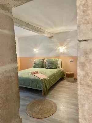 a bedroom with a green bed in a room at Suites zen dans maison d'hôtes avec piscine intérieure et jardin in Ventenac-Cabardès