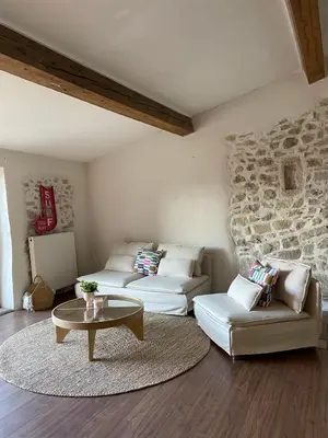 a living room with two couches and a stone wall at Suites zen dans maison d'hôtes avec piscine intérieure et jardin in Ventenac-Cabardès