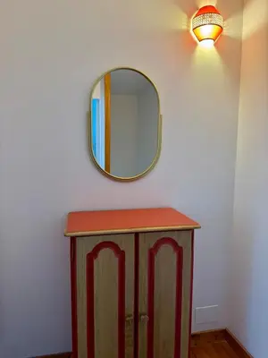 a mirror on a wall next to a wooden table at Canalentin in Castelnaudary