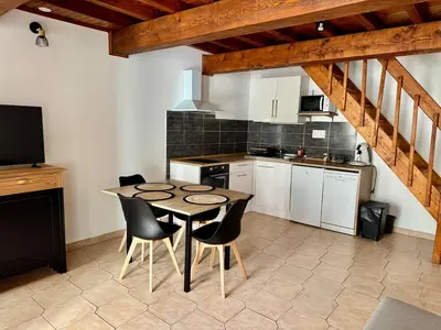 a kitchen with a table and chairs in a room at Canalentin in Castelnaudary