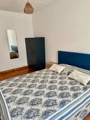a bedroom with a large bed with a blue headboard at Canalentin in Castelnaudary