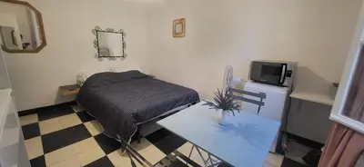 a room with a bed and a table and a tv at Chambre 1 - avec grande terrasse in Port-la-Nouvelle