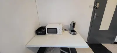 a white table with a microwave sitting on top of it at Chambre 1 - avec grande terrasse in Port-la-Nouvelle
