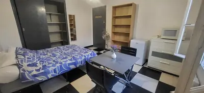 a small bedroom with a bed and a table at Chambre 2 - avec grande terrasse in Port-la-Nouvelle