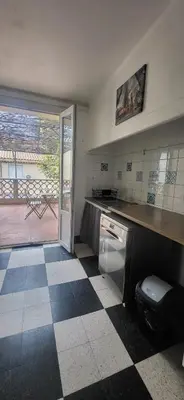a kitchen with a checkered floor and a counter top at Chambre 2 - avec grande terrasse in Port-la-Nouvelle
