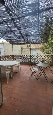 a patio with a table and chairs on a patio at Chambre 2 - avec grande terrasse in Port-la-Nouvelle