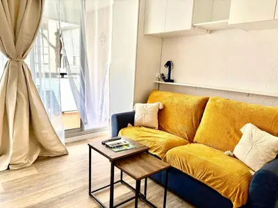 a living room with a yellow couch and a table at Ondine in Gruissan
