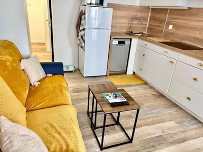 a living room with a couch and a table in a kitchen at Ondine in Gruissan