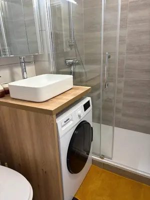 a washing machine in a bathroom with a shower at Ondine in Gruissan