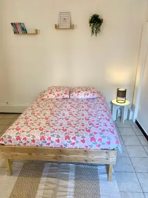 a bedroom with a bed with a floral bedspread at Studio Carcassonne Hyper Centre in Carcassonne