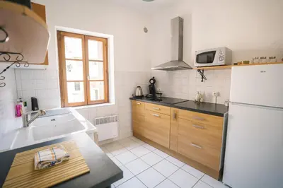 a kitchen with a white refrigerator and a sink at Charmant T2 au pied de la Cité de Carcassonne- AL in Carcassonne