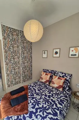 a bedroom with a bed and a chandelier at Charmant T2 au pied de la Cité de Carcassonne- AL in Carcassonne