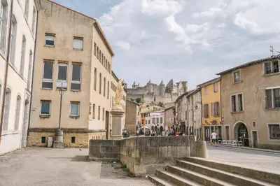 a city street with buildings and a castle in the background at Charmant T2 au pied de la Cité de Carcassonne- AL in Carcassonne