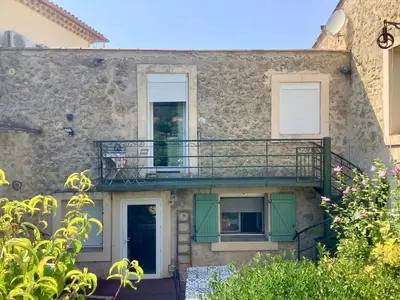 a building with a balcony on the side of it at Villa Bel Air in Puisserguier