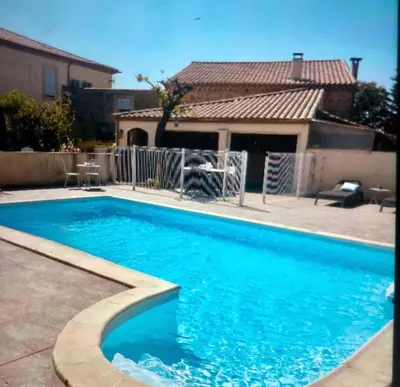 a large blue swimming pool in a yard at Villa Bel Air in Puisserguier
