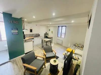 a living room with two chairs and a kitchen at Studette narbonaise in Narbonne