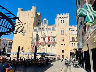 a large building with a tower with a clock on it at Studette narbonaise in Narbonne