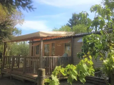 a wooden cabin with a porch and a deck at Mobil-home avec Terrasse à Lézignan-Corbières, 6 personnes - API-1-52-736 in Lézignan-Corbières