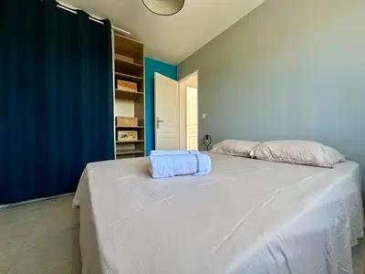 a white bed in a room with a blue wall at Villa FURGY - Climatisation et parking in Carcassonne