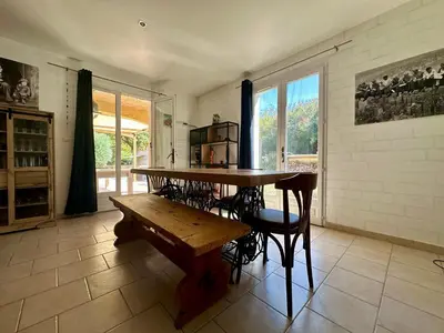 a dining room with a table and a bench at Villa FURGY - Climatisation et parking in Carcassonne