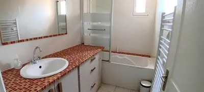 a bathroom with a sink and a shower and a tub at Villa Standing Piscine Chauffée in Gruissan