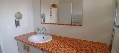 a bathroom with a sink and a mirror at Villa Standing Piscine Chauffée in Gruissan