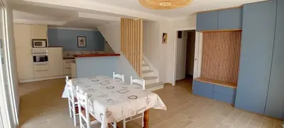 a kitchen and dining room with a table and chairs at Villa Standing Piscine Chauffée in Gruissan